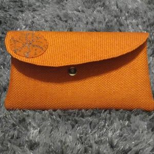 Handmade orange clutch with lining made in Kenya.
